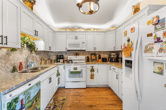 kitchen featuring white cabinetry, sink, light stone countertops, white appliances, and light wood-type flooring