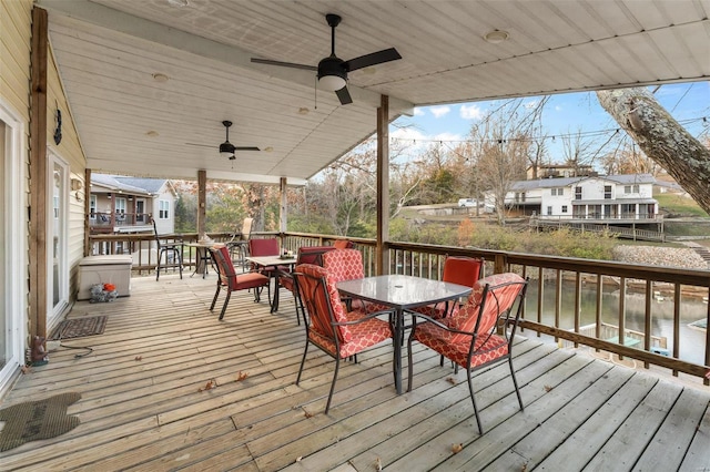 wooden deck with ceiling fan and a water view