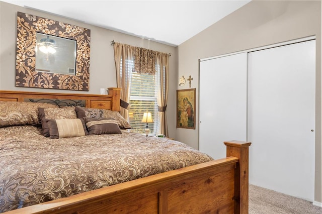 carpeted bedroom with a closet and lofted ceiling