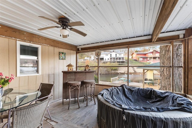 sunroom / solarium with ceiling fan, a healthy amount of sunlight, and wood ceiling