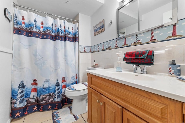 bathroom with tile patterned flooring, vanity, toilet, and tile walls