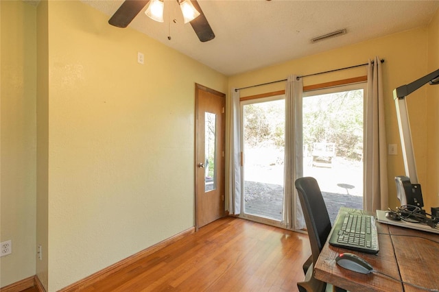 office space with a textured ceiling, light hardwood / wood-style flooring, and ceiling fan