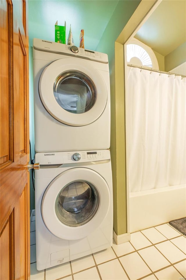 washroom featuring stacked washing maching and dryer and light tile patterned floors