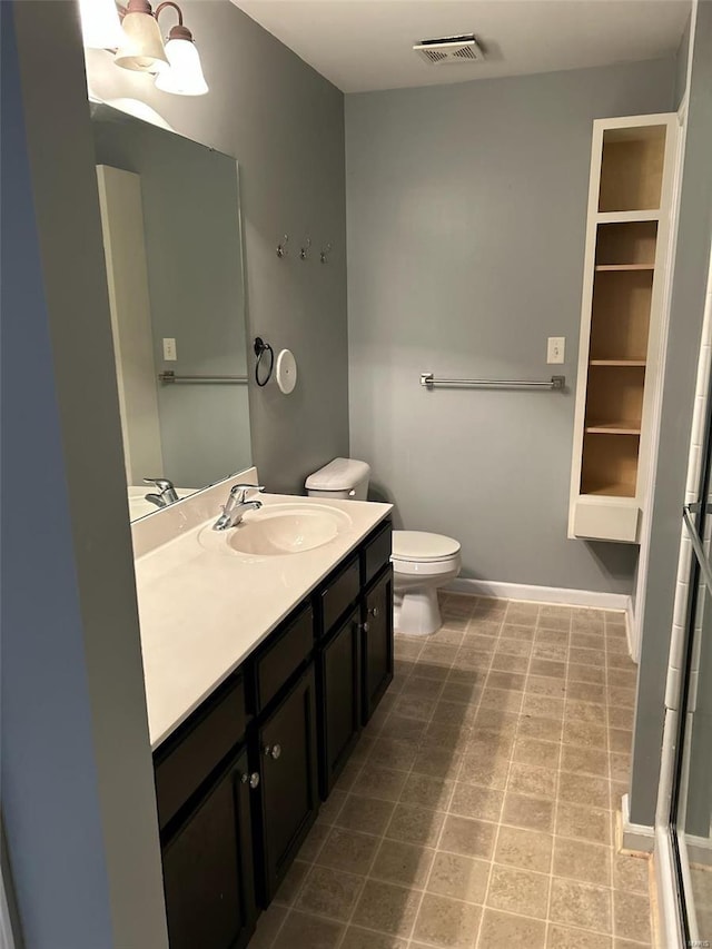 bathroom featuring a chandelier, vanity, and toilet