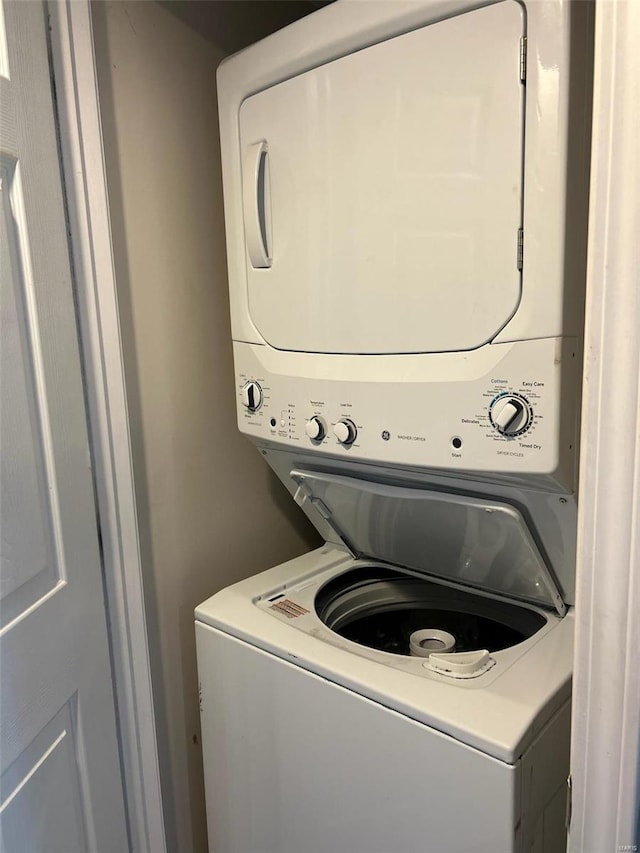 clothes washing area featuring stacked washer / dryer