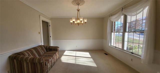 living area with carpet flooring, a chandelier, and ornamental molding