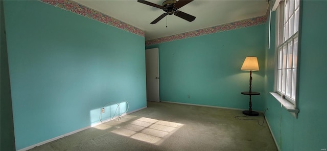 carpeted spare room with ceiling fan