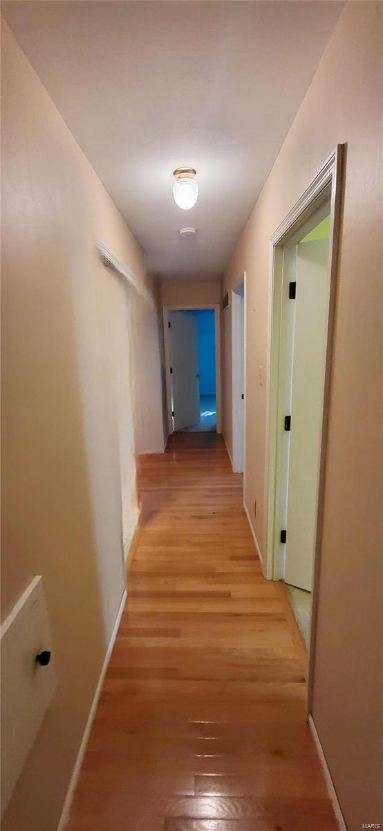 corridor with light hardwood / wood-style floors