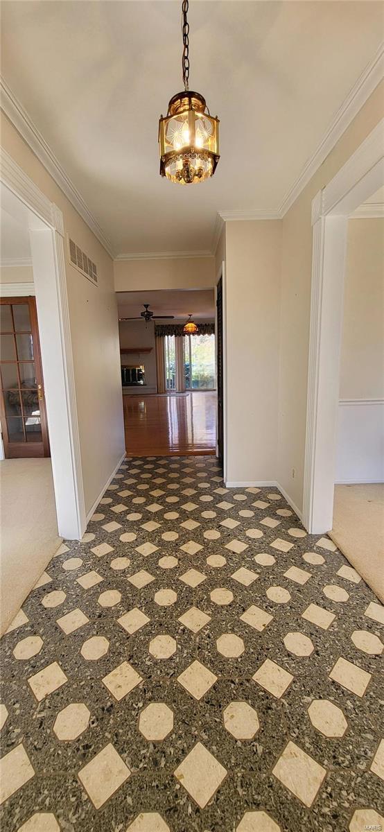 hall with carpet flooring and ornamental molding