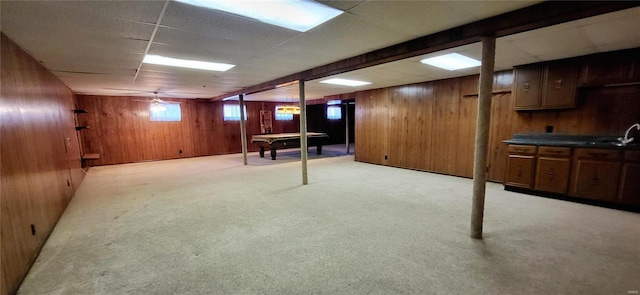 basement with light carpet, sink, wood walls, and billiards