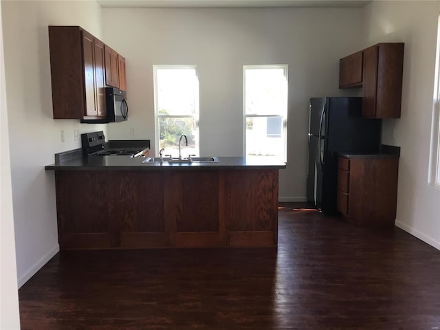 kitchen with dark hardwood / wood-style floors, sink, black appliances, and kitchen peninsula