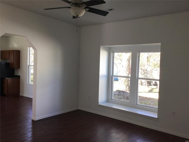 spare room featuring dark wood-type flooring and ceiling fan