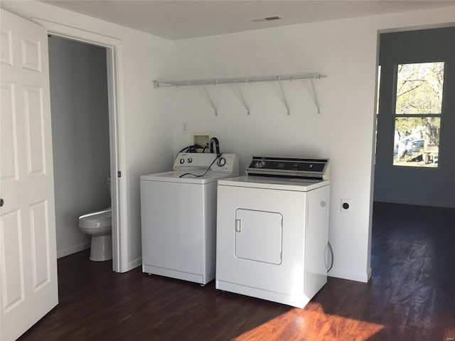 clothes washing area with washing machine and clothes dryer and dark hardwood / wood-style floors