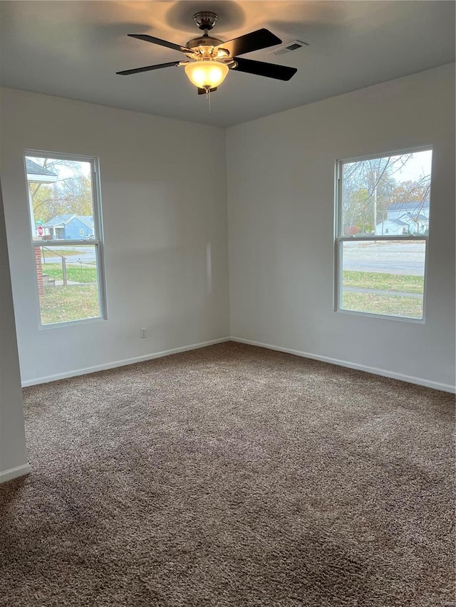 carpeted empty room with ceiling fan and a healthy amount of sunlight