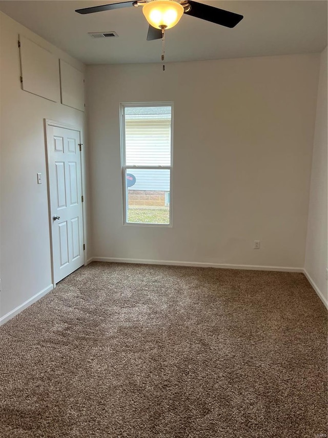 carpeted spare room featuring ceiling fan