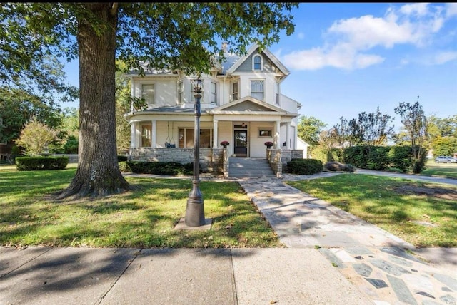 view of front facade with a front yard and covered porch