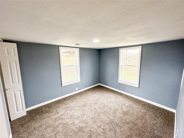 carpeted empty room featuring a textured ceiling