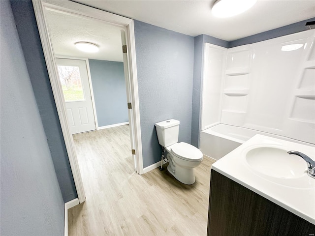 full bathroom featuring vanity, hardwood / wood-style flooring, toilet, a textured ceiling, and shower / bath combination