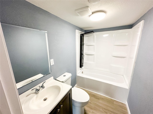 full bathroom with shower / bathtub combination, a textured ceiling, vanity, hardwood / wood-style flooring, and toilet