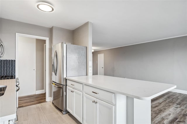 kitchen featuring stainless steel refrigerator, white cabinets, and light hardwood / wood-style floors