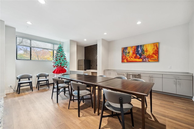 dining space with light hardwood / wood-style floors and a fireplace