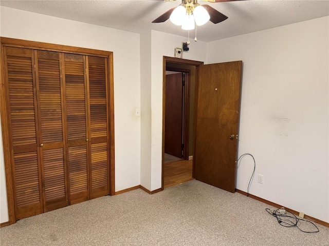 unfurnished bedroom featuring a closet, a textured ceiling, ceiling fan, and carpet floors