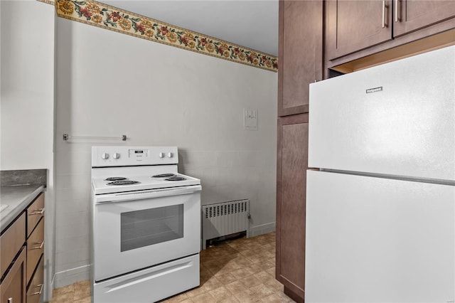 kitchen featuring radiator heating unit and white appliances