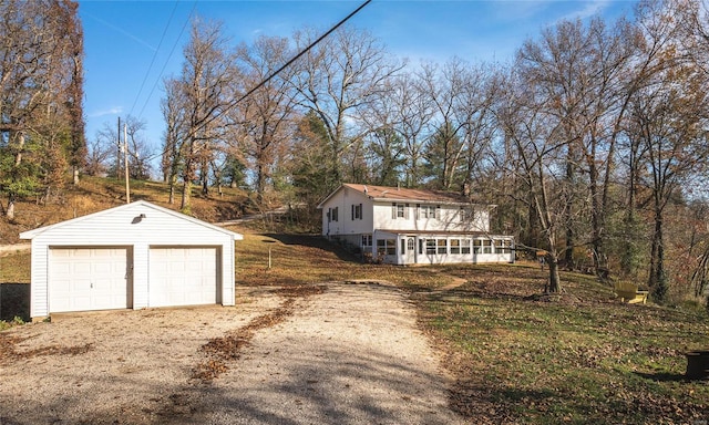 view of front of house with an outbuilding, a garage, and a sunroom