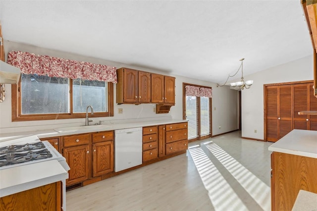 kitchen with white dishwasher, a wealth of natural light, pendant lighting, and vaulted ceiling