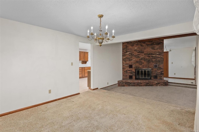 unfurnished living room featuring an inviting chandelier, a textured ceiling, light carpet, and a brick fireplace