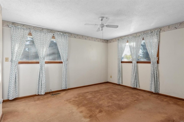 carpeted spare room featuring a textured ceiling and ceiling fan