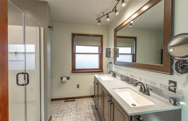 bathroom with an enclosed shower, vanity, and rail lighting