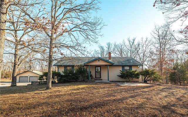 single story home with an outbuilding, a garage, and a front yard