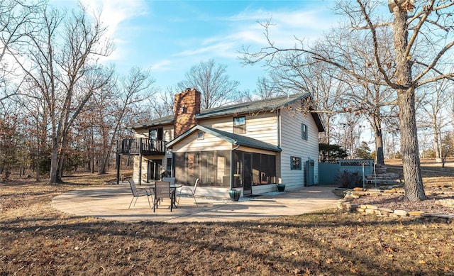 rear view of property with a patio, a sunroom, and a lawn