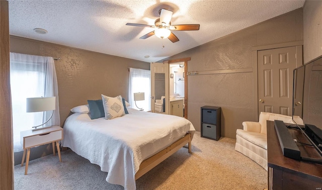 carpeted bedroom featuring connected bathroom, ceiling fan, vaulted ceiling, and a textured ceiling