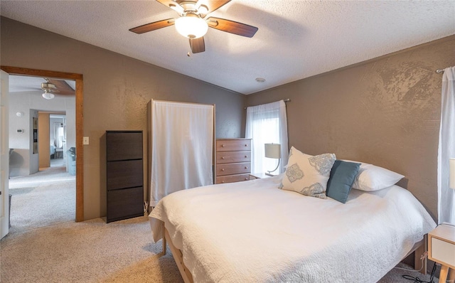 bedroom featuring ceiling fan, lofted ceiling, light carpet, and a textured ceiling