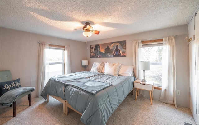 carpeted bedroom with multiple windows, a textured ceiling, and ceiling fan