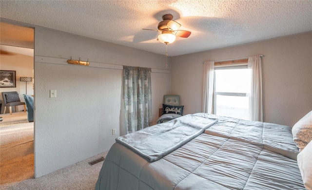 bedroom featuring ceiling fan, a textured ceiling, and carpet