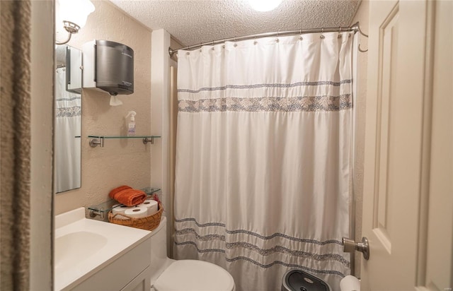 bathroom with vanity, toilet, and a textured ceiling