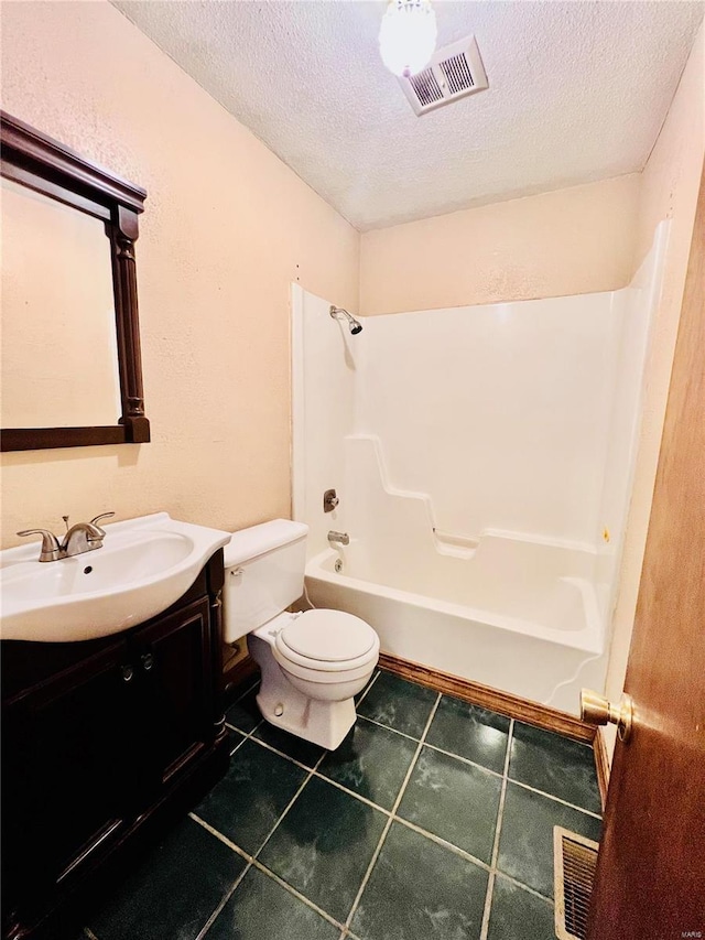 full bathroom with tile patterned flooring, a textured ceiling, tub / shower combination, vanity, and toilet