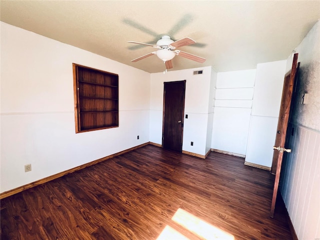 unfurnished bedroom featuring dark wood-type flooring and ceiling fan