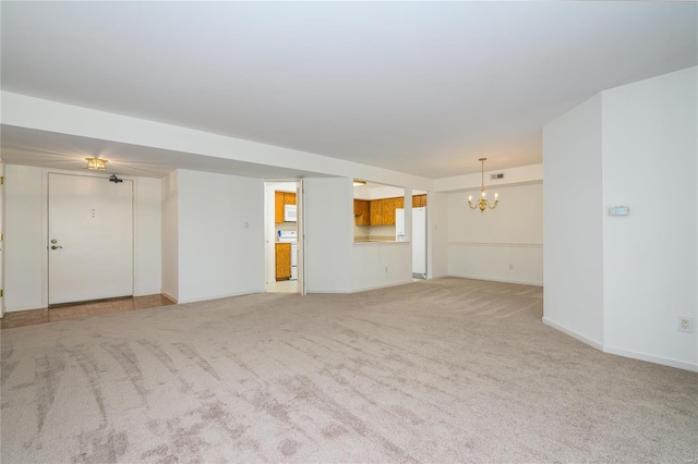 unfurnished living room featuring a notable chandelier and light colored carpet