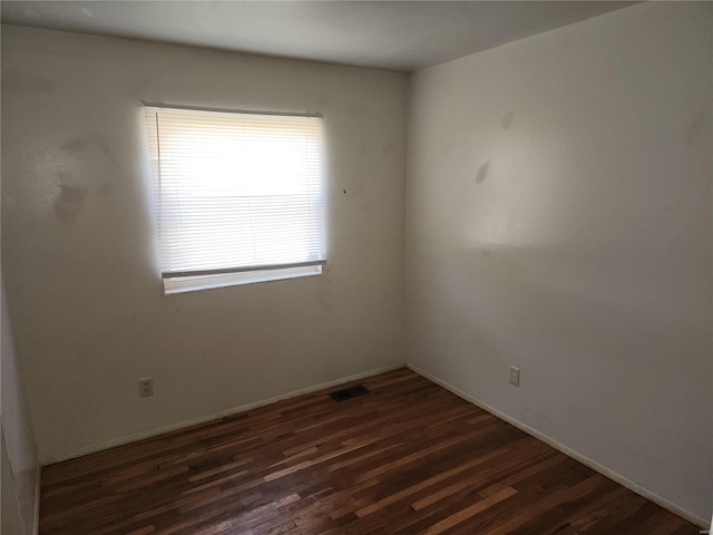 spare room with dark wood-type flooring