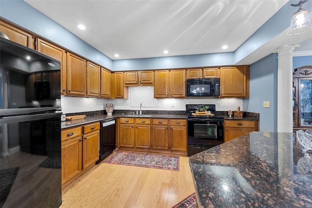 kitchen featuring ornate columns, light hardwood / wood-style floors, decorative backsplash, black appliances, and ornamental molding