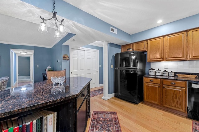 kitchen featuring dark stone counters, black appliances, tasteful backsplash, decorative light fixtures, and light hardwood / wood-style floors