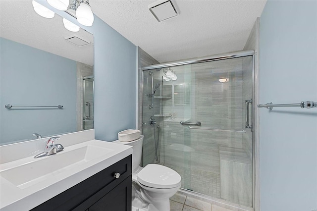 bathroom with tile patterned flooring, vanity, toilet, and a textured ceiling