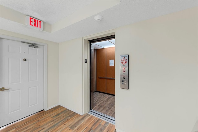 hallway featuring a textured ceiling and hardwood / wood-style flooring