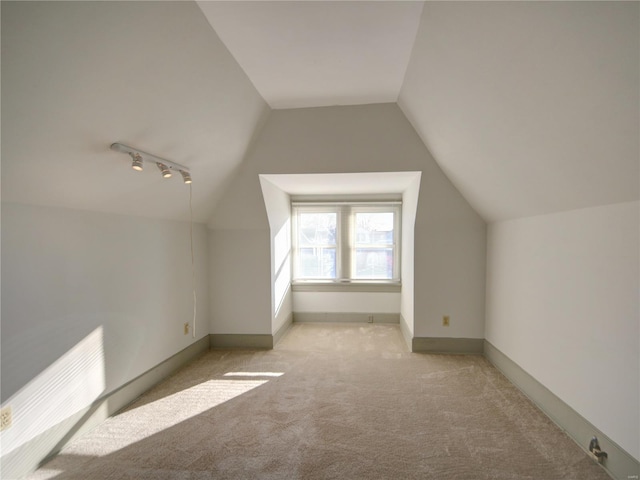 additional living space with light colored carpet and vaulted ceiling