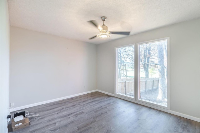 spare room featuring hardwood / wood-style flooring, ceiling fan, and a textured ceiling