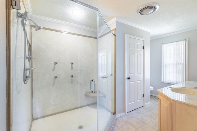 bathroom with a textured ceiling, vanity, crown molding, toilet, and a shower with shower door